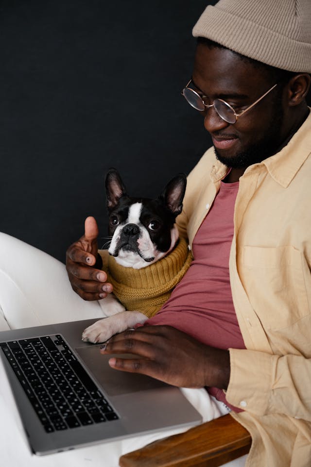 man sitting at a laptop with dog